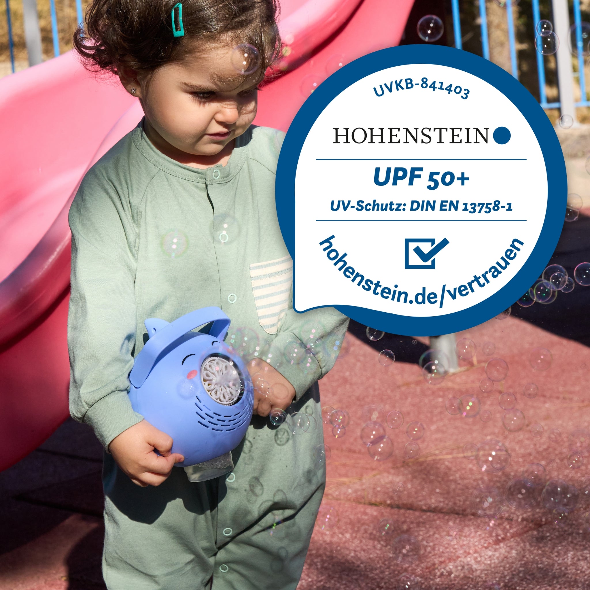 UPF50+ Zertifikat vom Hohenstein Institut auf einem Bild mit einem Kleinkind, welches einen UPF50+ Body trägt und eine Seifenblasen Maschine trägt.